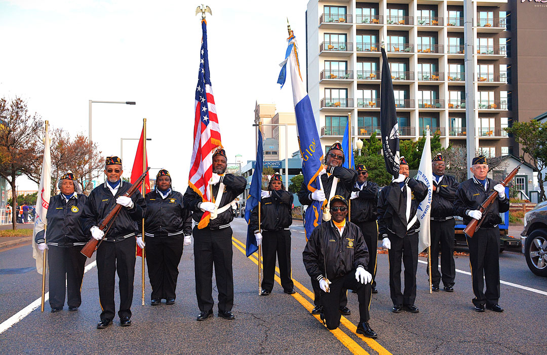 American Legion Honor Guard for the 2nd District of the Virginia Department, prepares to lead a contingency of marching legionnaires, floats, and vehicles in the Veterans Day Parade on November 11, 2024 in Virginia Beach, VA.  Otha Newton (kneeling) is the Honor Guard Commander.  (Photography by Bert Wendell, Jr.)