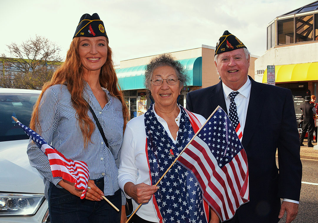 Legionnaires from the SSgt Robert C. Melberg, U.S. Army, American Legion Post 110 of Virginia Beach, VA prepare to fall in behind the American Legion Honor Guard to march in the Veterans Day Parade on November 11, 2024 in Virginia Beach, Va.  In the photo (L to R) are Legionnaire Emily Wolf, Auxiliary Unit 110 member Jesse Basso and Post 110 Commander Ron Basso.  (Photography by Bert Wendell, Jr.)