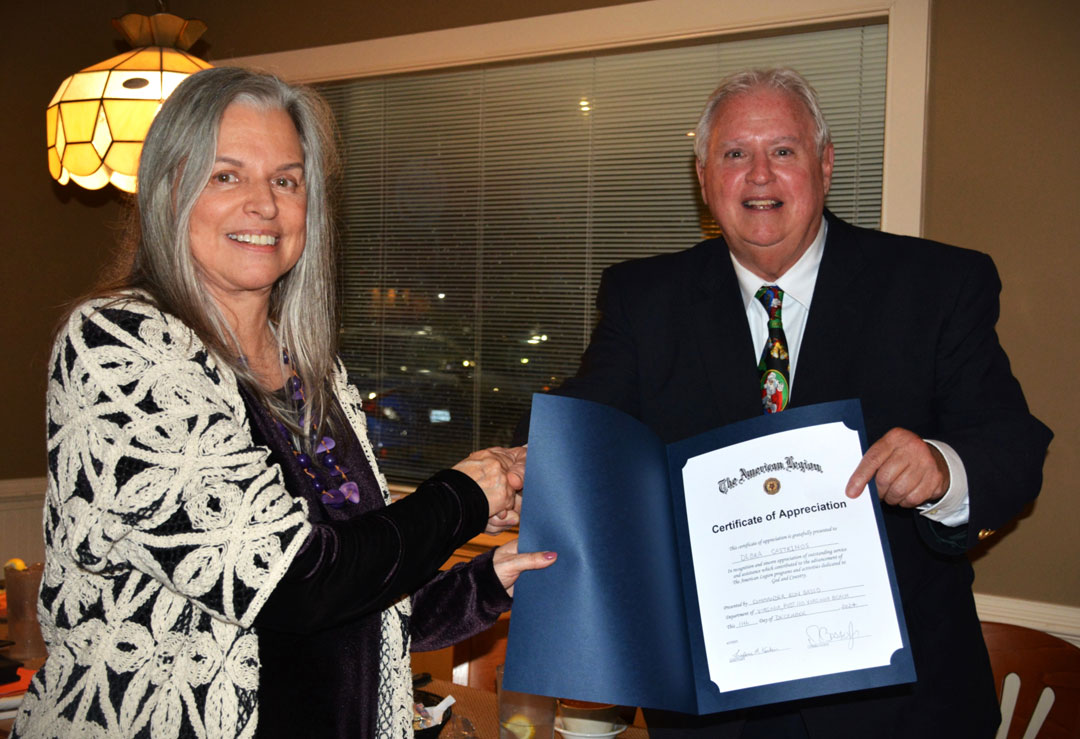 The SSgt Robert C. Melberg, U.S. Army, American Legion Post 110 held its annual Christmas Party on December 11, 2024 at Gus and George's Restaurant in Virginia Beach, VA.  Prior to setting down for a great meal, Post Commander Ron Basso (right) presented an 'American Legion Certificate of Appreciation' to Legionnaire Debra Castrinos (left) in recognition for her diligent efforts in initiating the required application and recruitment of post members to organize a Chapter of American Legion Riders within Post 110.  Post 110's Riders are awaiting their official charter from American Legion National Headquarters in Indianapolis, IN.  Those attending the party were Rick & Tonya Jones, Ron & Jesse Basso, Dave & Dale Smith, Fred & Mary Kinkin, Debra Castrinos, Cyndi Fisher, Jon & Linda Asher, Kevin & Morningstar Graves, Bob Russell, Jane McKeel, Eric Bell, Emily & Julian Wolfe, Chris Allison, George Schmidt, Carolyn Hink, and Bert, Woody, & Vicky Wendell.  (Photography by Bert Wendell, Jr.)