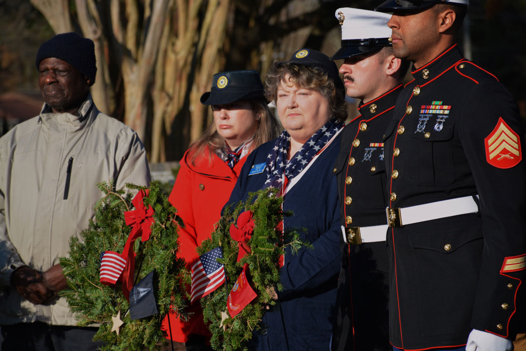 Laying wreaths on the graves of military veterans were many volunteers including (L to R) an unnamed civilian, Alicia Baqueroalvarez & Tonya Jones of Post 110, and two unnamed Marines in dress uniform.  (Photography by Bert Wendell, Jr.)