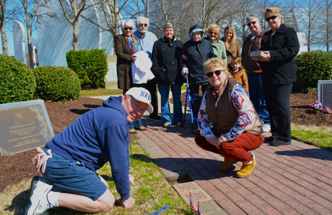 ALocated just behind the Tidewater Veterans Memorial on 19th Street in Virginia Beach, VA is the Veterans Memorial Park.  At this park, Memorial Pavers are laid in memory of deceased veterans by their family members to honor their loved ones military service.  On March 26, 2025, a slightly chilly morning with bright sunshine, three area families gathered to lay Memorial Pavers for CWO2 Ned A. Clark, USN, (Ret), MS1 W.W. Carlson, USN, (Ret) and CWO2 Louis Tingen, USN, (Ret).  Assisting them was Joe Mahachek, a retired U.S. Navy Officer, and a member of the Virginia Beach Mayor's Veterans Council.  Mahachek volunteers to assist family's in ordering, scheduling and laying the pavers.  He takes this responsibility very seriously along with his volunteer work with the SSgt Robert C. Melberg, U.S.A., American Legion Post 110 of Virginia Beach, VA.  In the photo (left to right) are (front row kneeling) Joe Mahachek & Sally Carlson and (back row standing) are Kim Bowles, Danny Carlson, Beth Coulling, Etta Clark, Pam Howell, Kendall Reed, Stevie Reed, Steve Howell, & Julie Clark.  Absent from the photo was Cindy Tingen.  (Photography by Bert Wendell, Jr.)